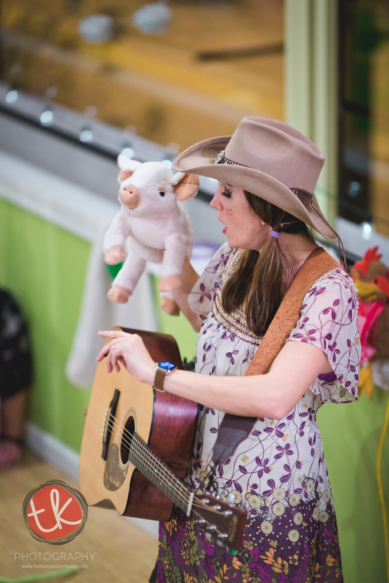 Miss Jamie performing with a guitar and a pig puppet